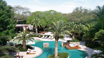 Alberca al aire libre, sombrillas en la alberca y camastros