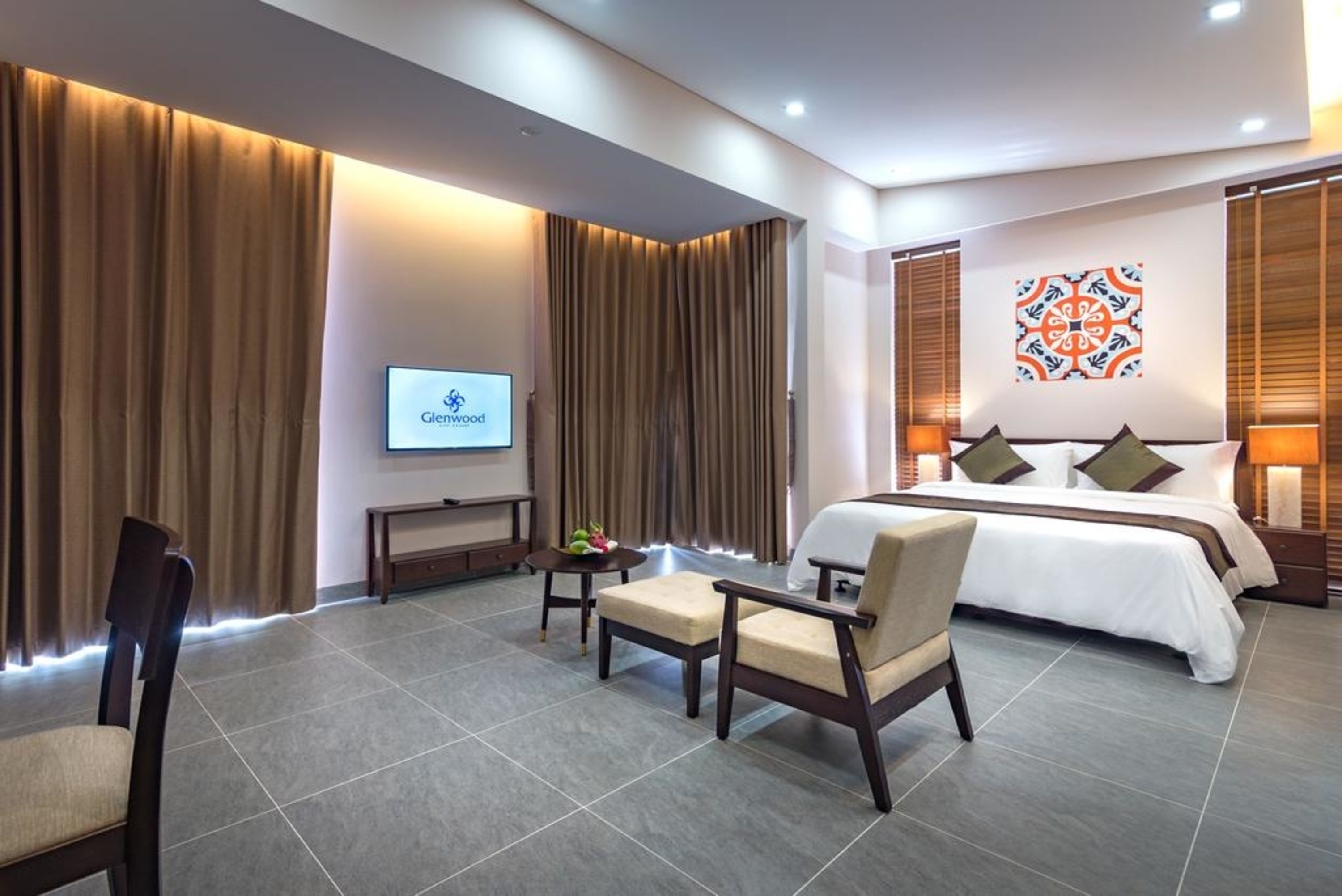 Una habitación de hotel con cama, televisor, escritorio y silla.
