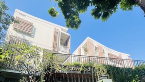 A modern building with a gated entrance, a staircase leading to the entrance, and a sign indicating the name 'Glenwood City Resort'. - Glenwood City Resort (Ho Chi Minh City)