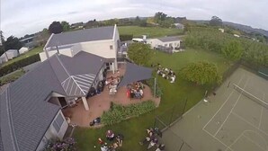 A residential area with a large house featuring a sloped roof and a covered patio area. - Cottages on St Andrews (Havelock North)