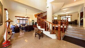 A spacious living area with a wooden staircase, a large window, and a decorative ship model. - Warmhouse (Taitung)