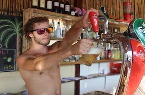 A person pouring beer from a tap labeled "Angkor" into a glass.
