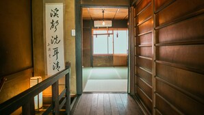 Et traditionelt japansk interiør med trægulv, tatamimåtte og en shoji-skydedør.