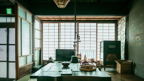 Et traditionelt japansk rum med tatamimåtter, et lavt bord med te-service og en skydedør.
