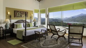 A bedroom with a large bed, two nightstands, a chair, a view of mountains and a lake. - The Albatross, Kandy (Maberiyatenna)