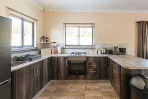 Een koelkast met diepvriezer, een microgolfoven, een oven, een kookplaat