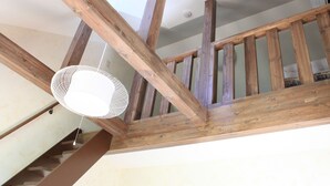 A wooden staircase with a white hanging light fixture. - Petit Hotel Blanc Fleur (Nakafurano)