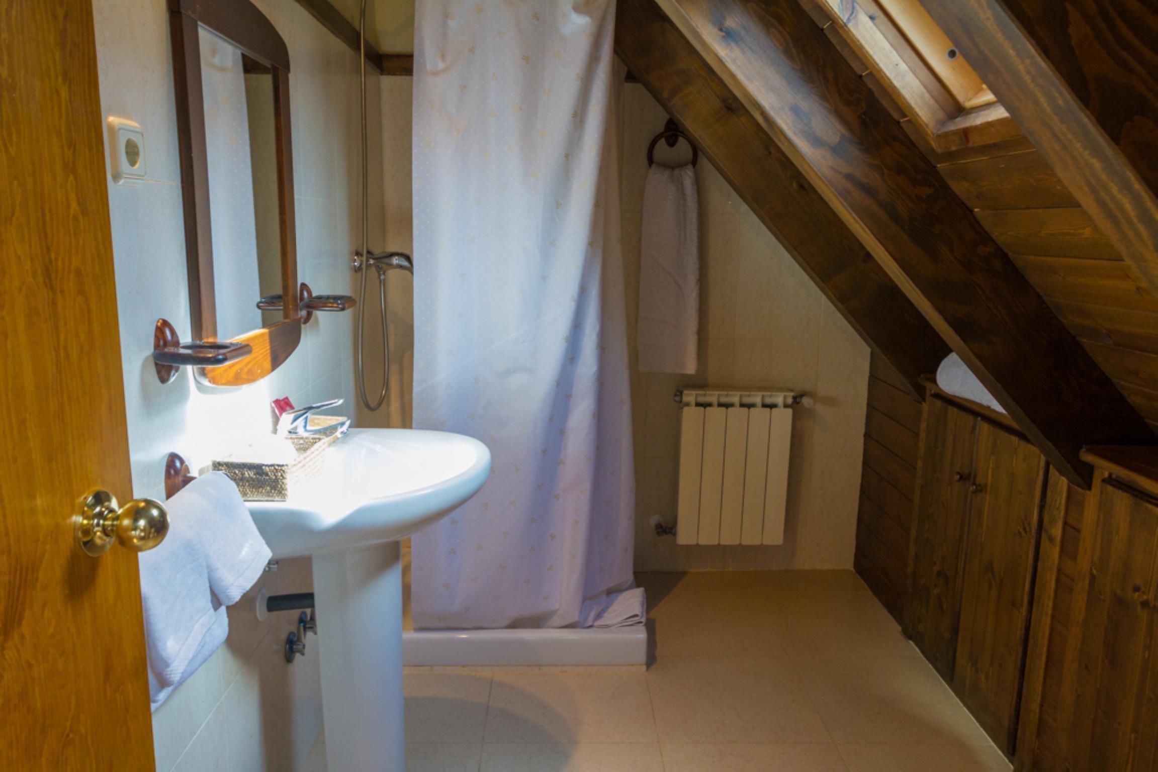 A bathroom with a wooden ceiling, a white sink, and a shower curtain.