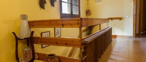 A wooden staircase with a handrail, a vase, and a wall-mounted decorative item.