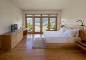 Un dormitorio con cama, escritorio y televisor.