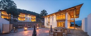 Um hotel moderno com vários quartos, área de estar externa e uma parede de pedra.