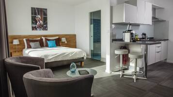 Une chambre d’hôtel avec un lit, un bureau et une kitchenette.