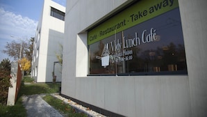 Un edificio moderno con letrero de cafetería y restaurante.