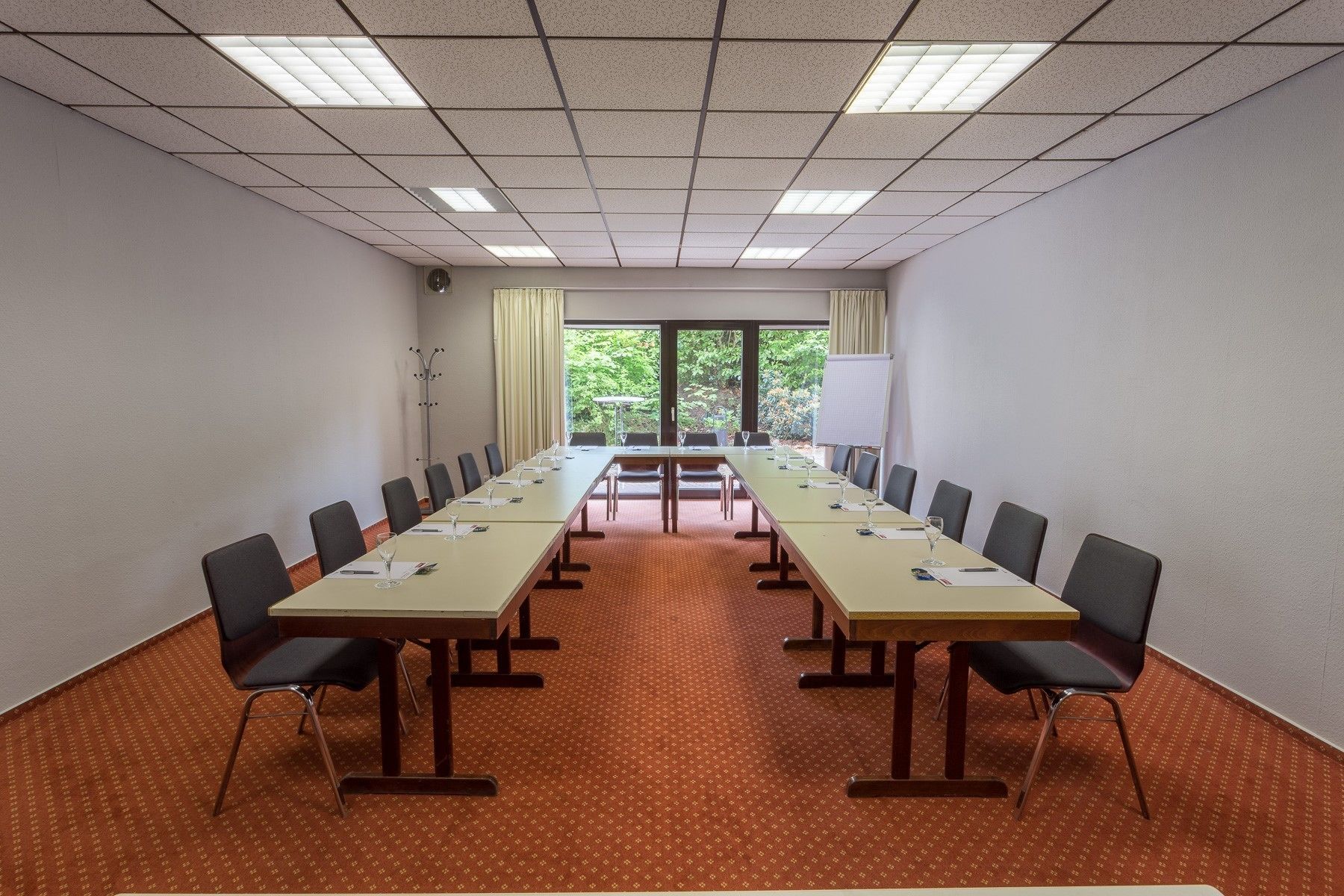 A conference room with a long table, chairs, and a projector screen.