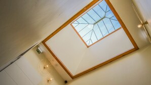 A room with a skylight, a ceiling fan, and a light fixture. - Bairro Alto Suites (Lisbon)