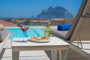 Piscina all'aperto, una piscina in terrazza, lettini