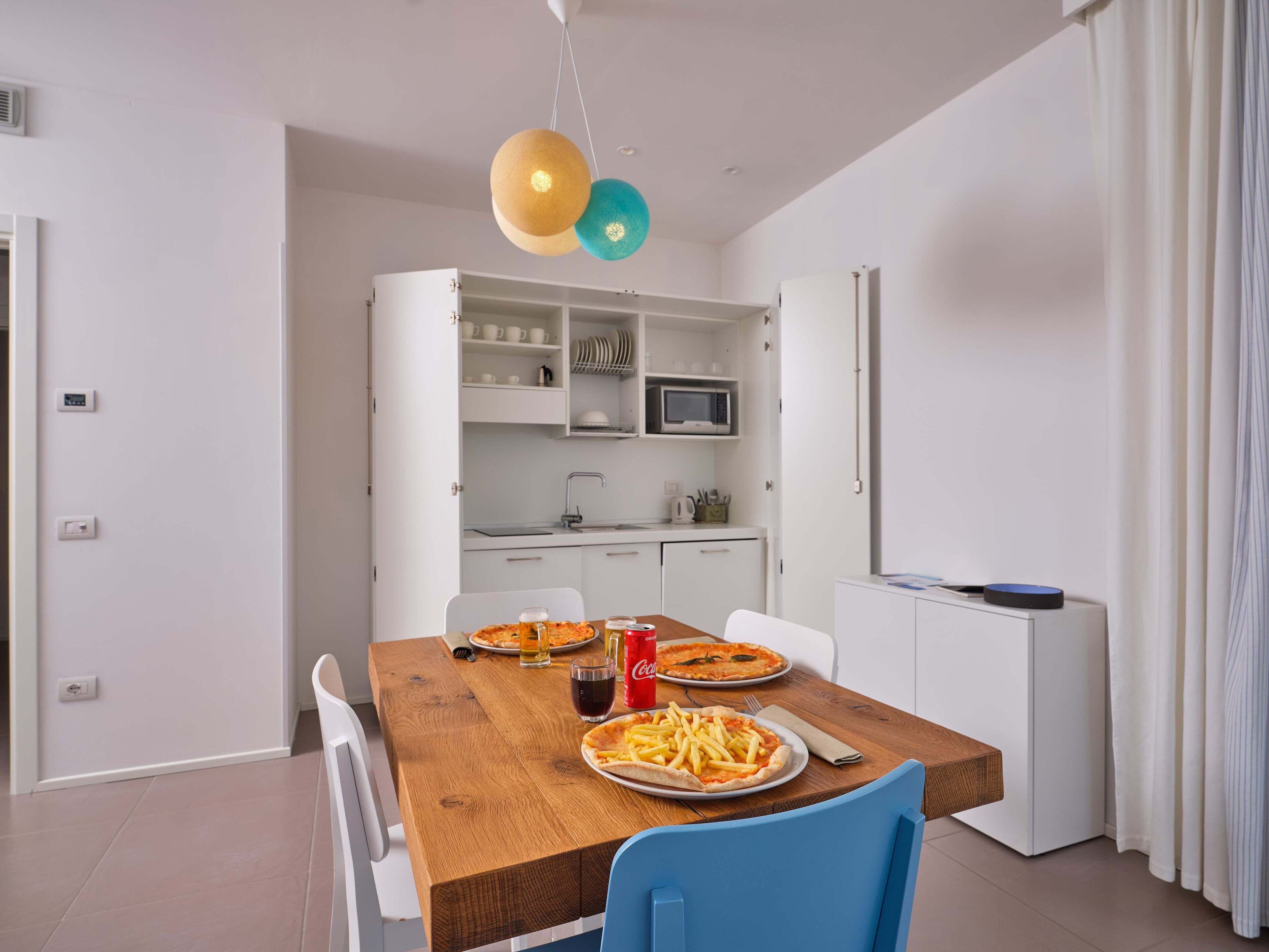 Una cocina moderna con armarios blancos, un microondas y un fregadero.