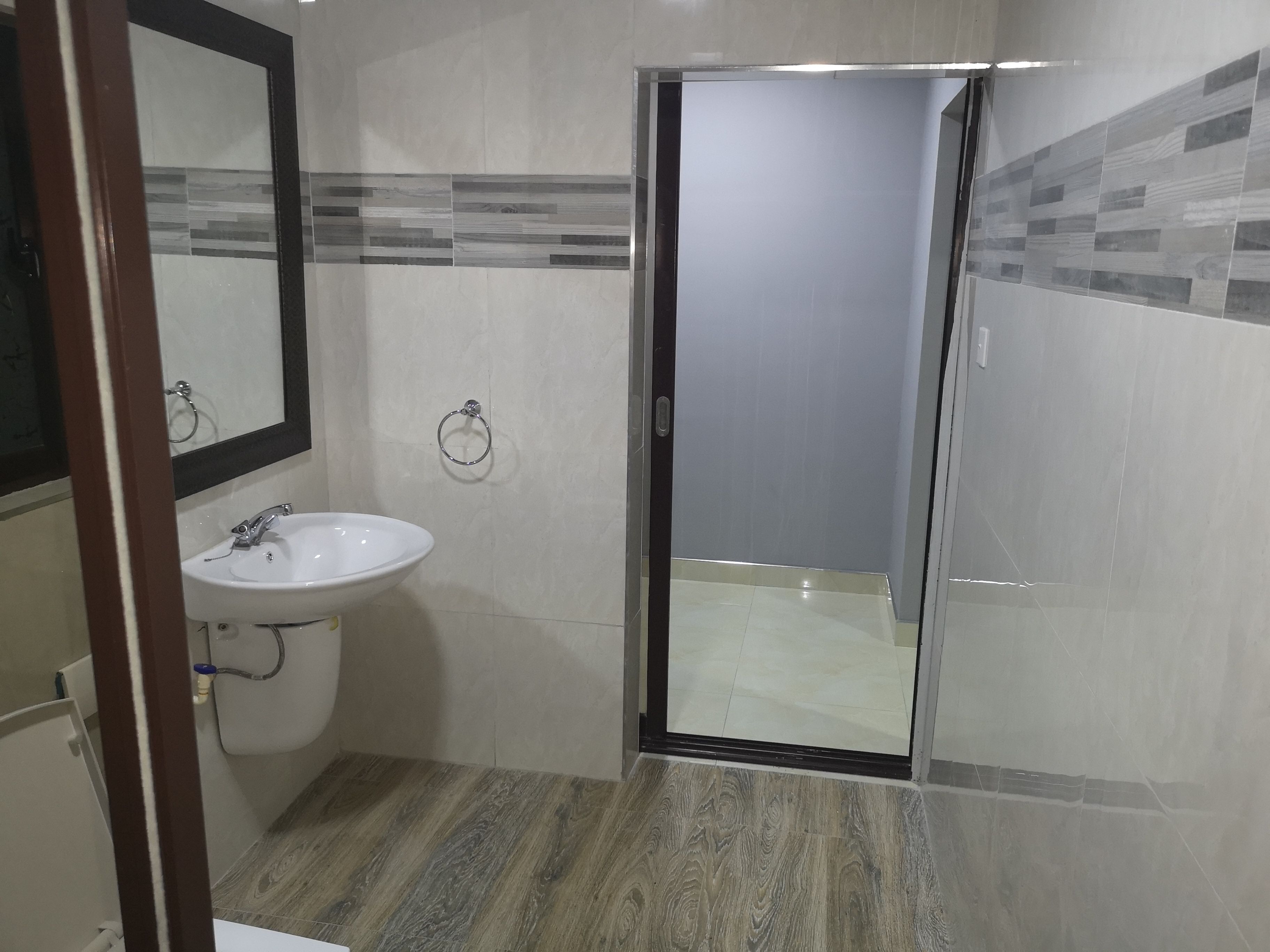 A bathroom with a sink, mirror, and shower area.