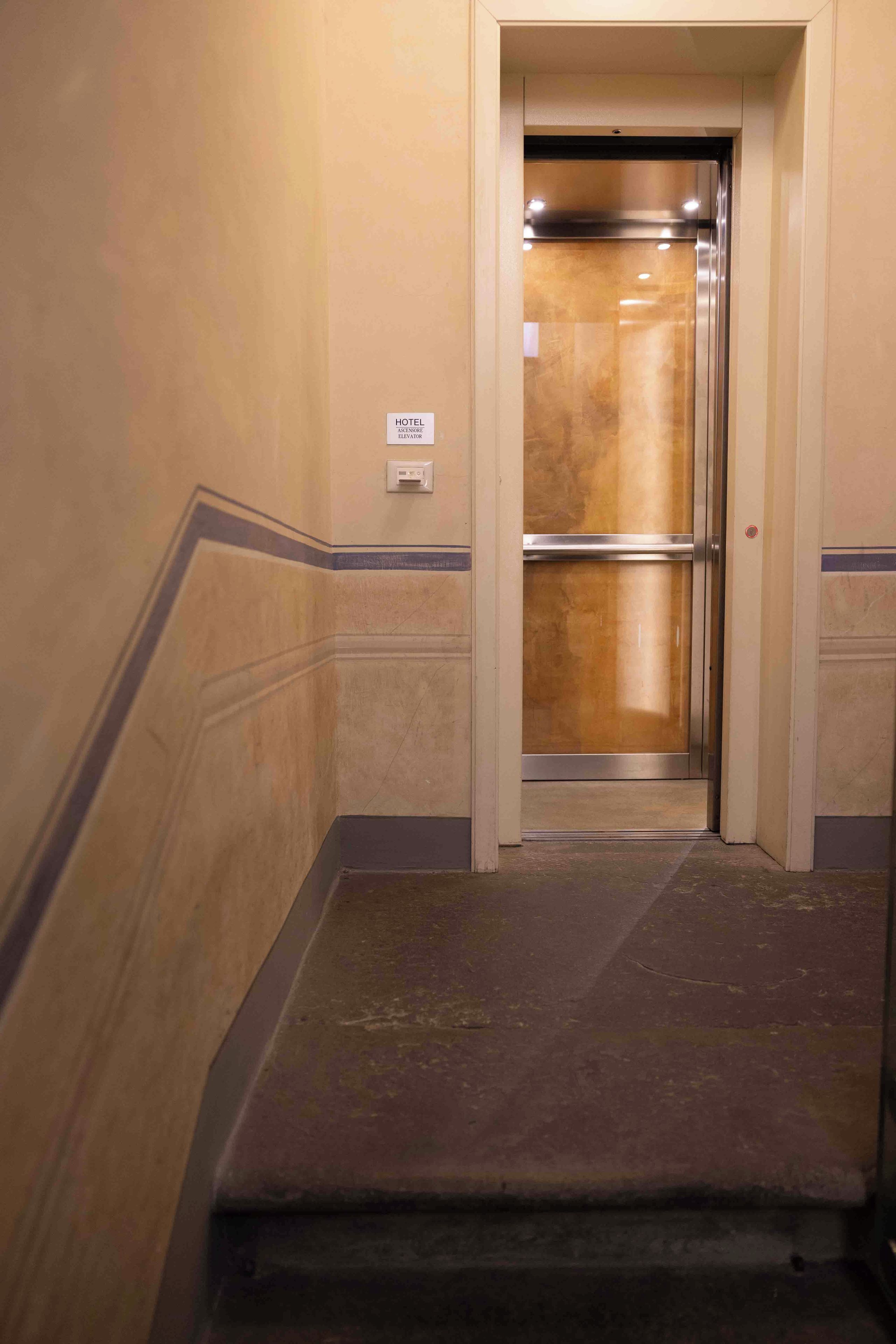 A hotel elevator with a sign indicating its location.