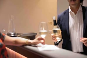 A hotel reception area with a counter, a wine bottle, and a glass of wine. - Hotel Renaissance (Florence)