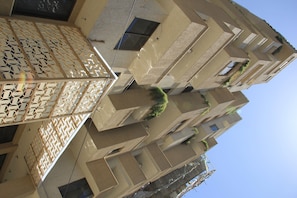 A multi-story building with a modern architectural design, featuring balconies and windows. - Momona Hotel (Addis Ababa)