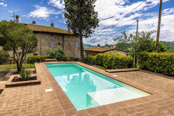 Una piscina al aire libre de temporada, sombrillas