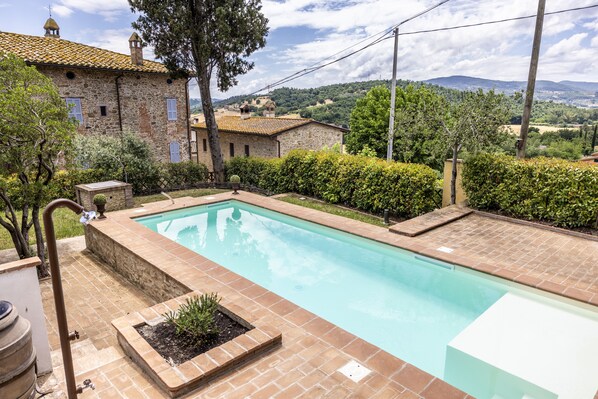 Una piscina al aire libre de temporada, sombrillas