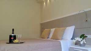 Een verzorgde hotelkamer met een bed, nachtkastje en een kleine potplant.