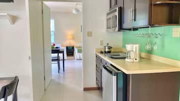 A modern kitchen with stainless steel appliances, a coffee maker, and a wine rack.