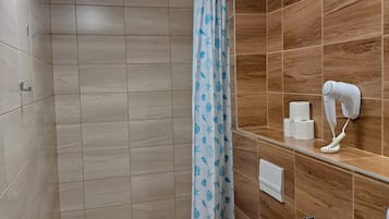 Une salle de bain équipée d’une douche, de toilettes, d’un lavabo et d’un porte-serviettes.