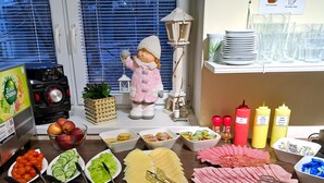 Une table de buffet proposant divers plats, accompagnements et ustensiles.