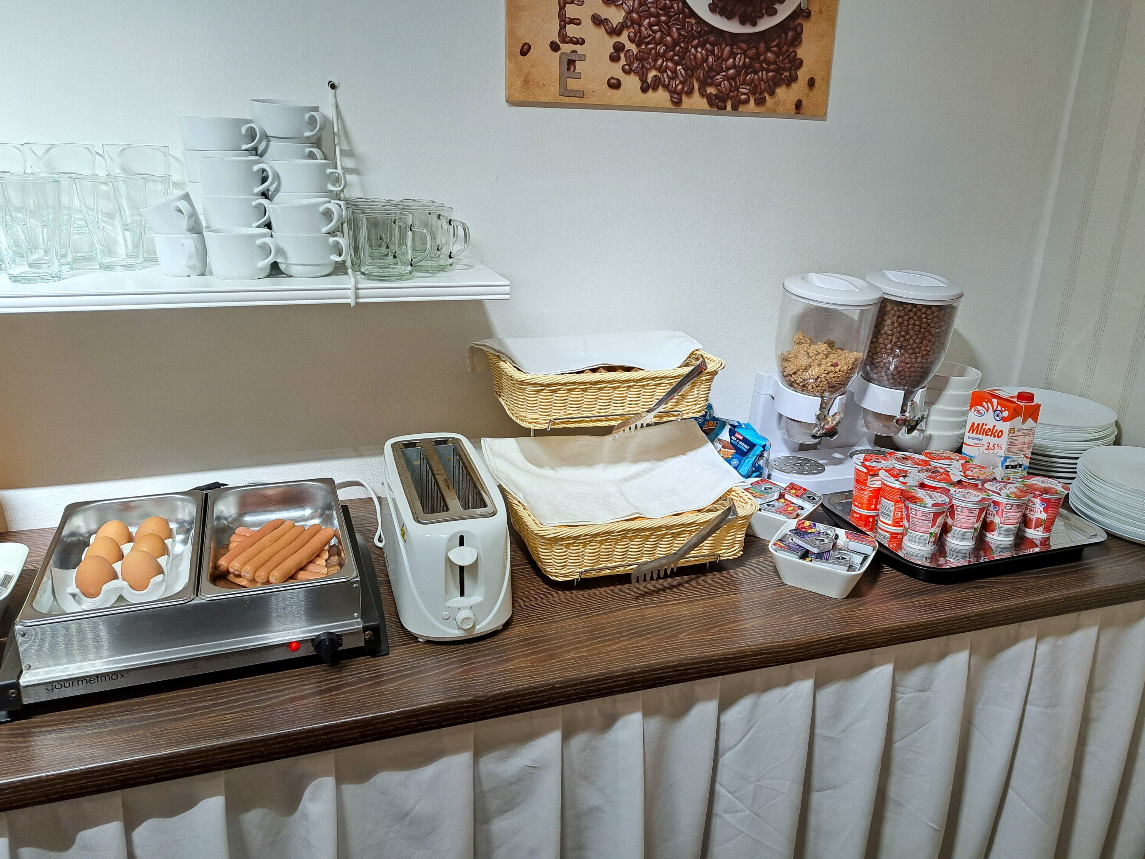 A breakfast buffet with various food items and utensils.