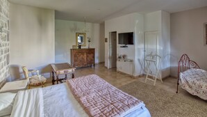 A bedroom with a bed, a dresser, a TV, a chair, and a desk. - Domaine des Chais (Thenac)