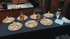 A table set with multiple plates of assorted appetizers, bottles of drinks, and a thermos. - Domaine des Chais (Thenac)