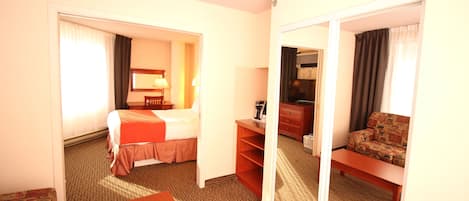 A hotel room with a bed, a desk, a sofa, and a mirror.