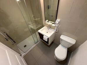 Habitación ejecutiva | Baño | Tina con regadera y toallas 