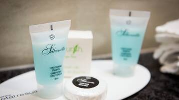 Deux bouteilles de shampoing démêlant de la marque Silhouette et un savon, le tout posé sur un plateau blanc.