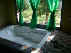A bathroom with a bathtub, green curtains, and a checkered floor. - Pousada dos Tucanos (Sao Thome das Letras)