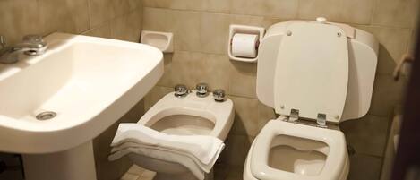 Un baño con lavamanos, un bidé y un inodoro.