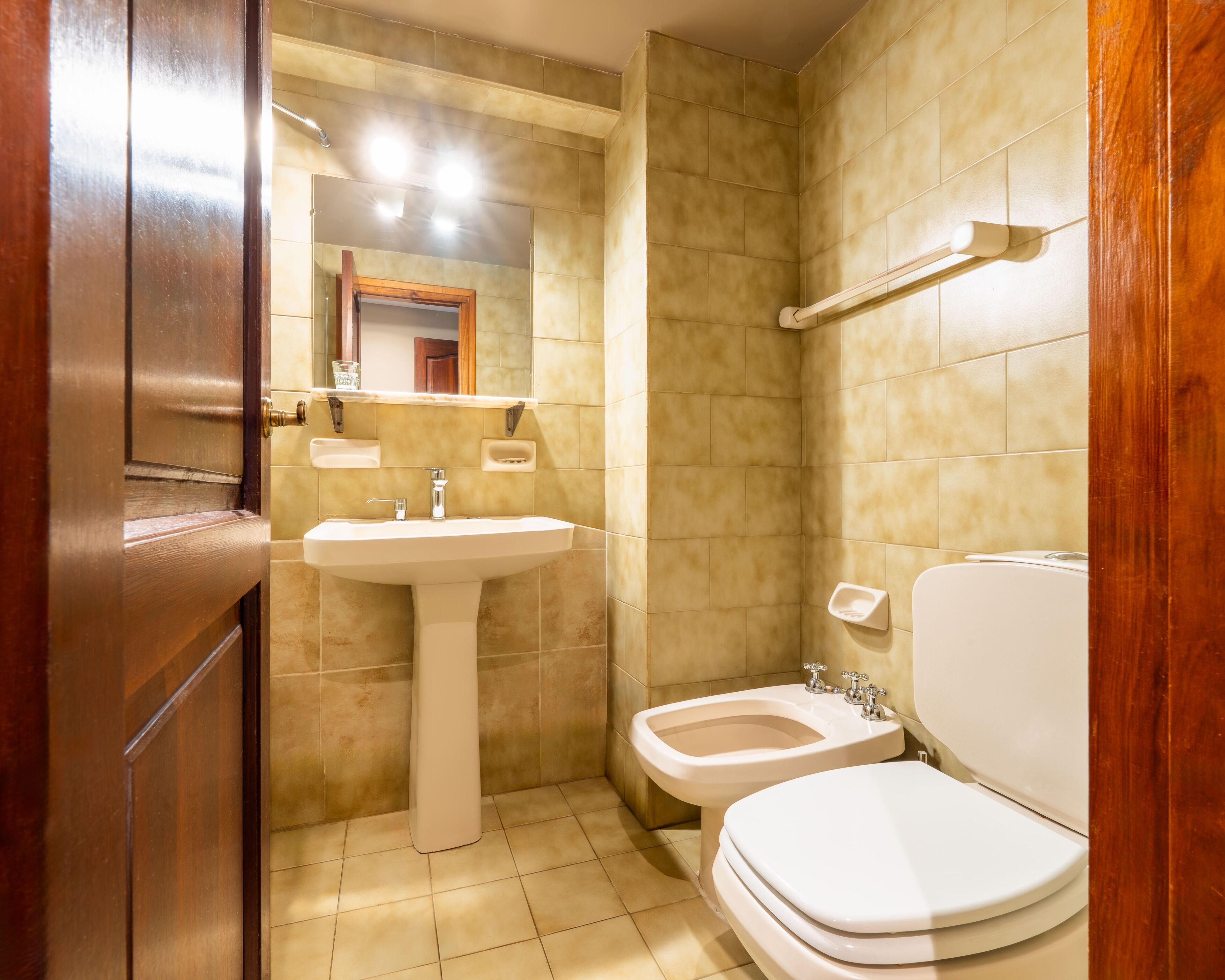 Een badkamer met een wastafel, toilet en bidet.