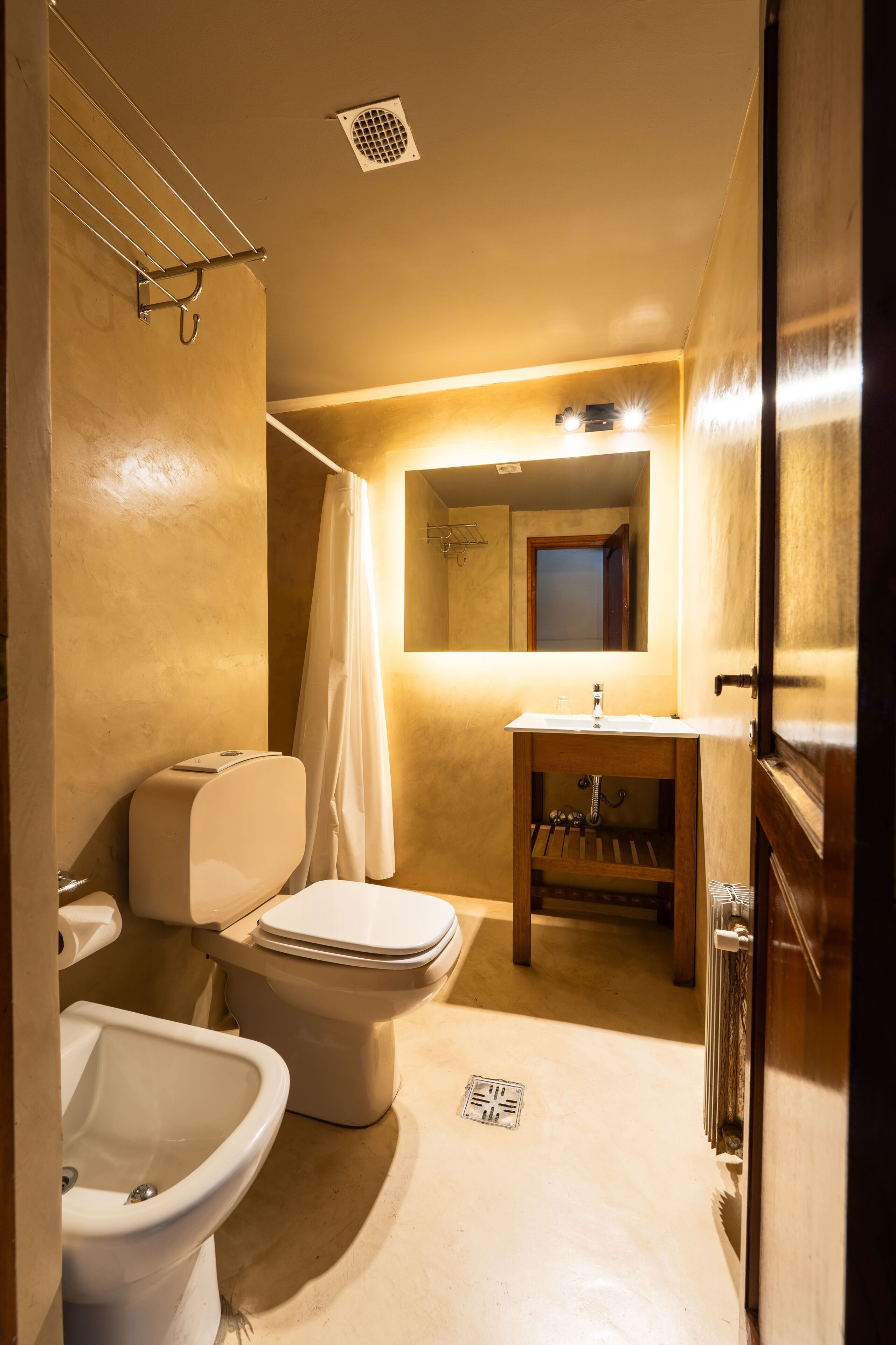 Un baño pequeño con inodoro, bidé y lavamanos.