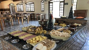 A buffet area with various food items and a brick counter. - Hotel Gran Minas (Vespasiano)