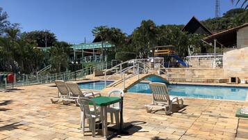 Relax by the pool surrounded by a deck with comfortable seating and a nearby playground for kids.