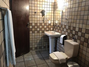 A bathroom with a toilet, sink, and towel rack. - Hotel Gran Minas (Vespasiano)