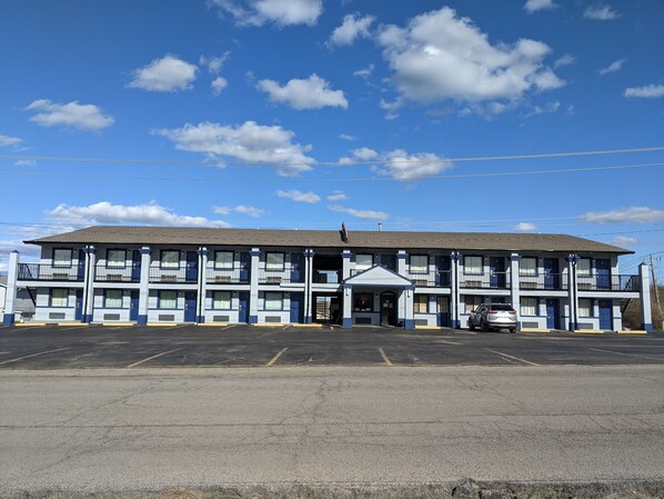 A motel with a central entrance, multiple balconies, and a parking lot. - Eufaula Inn (Eufaula)