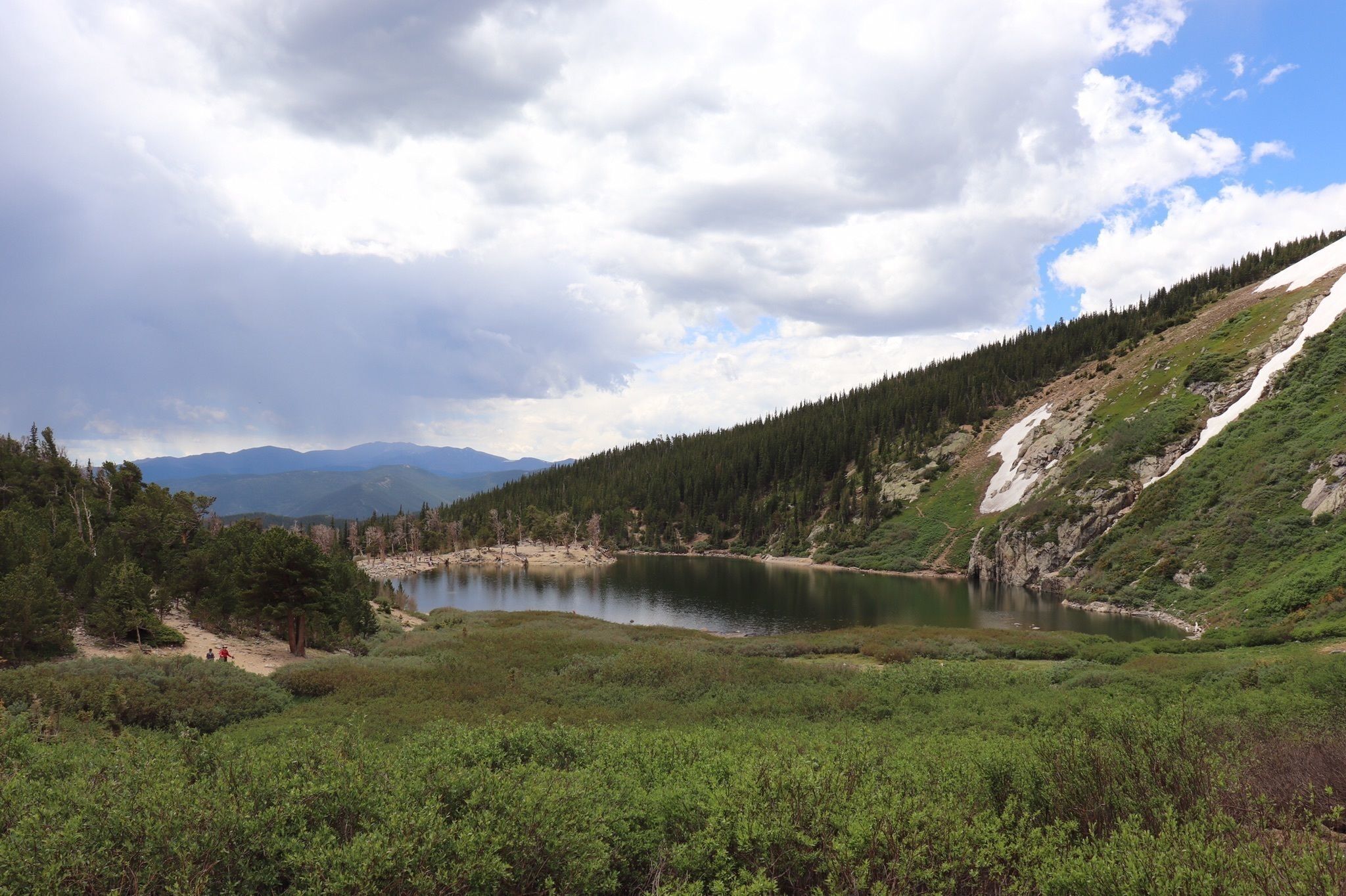 Un lac entouré de collines et de montagnes boisées.