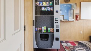 A vending machine with snacks and drinks, a coffee machine, and a wall-mounted sign. - Heidelberg Motel by Capital O Bridgeport Frankenmuth I 75 (Bridgeport)