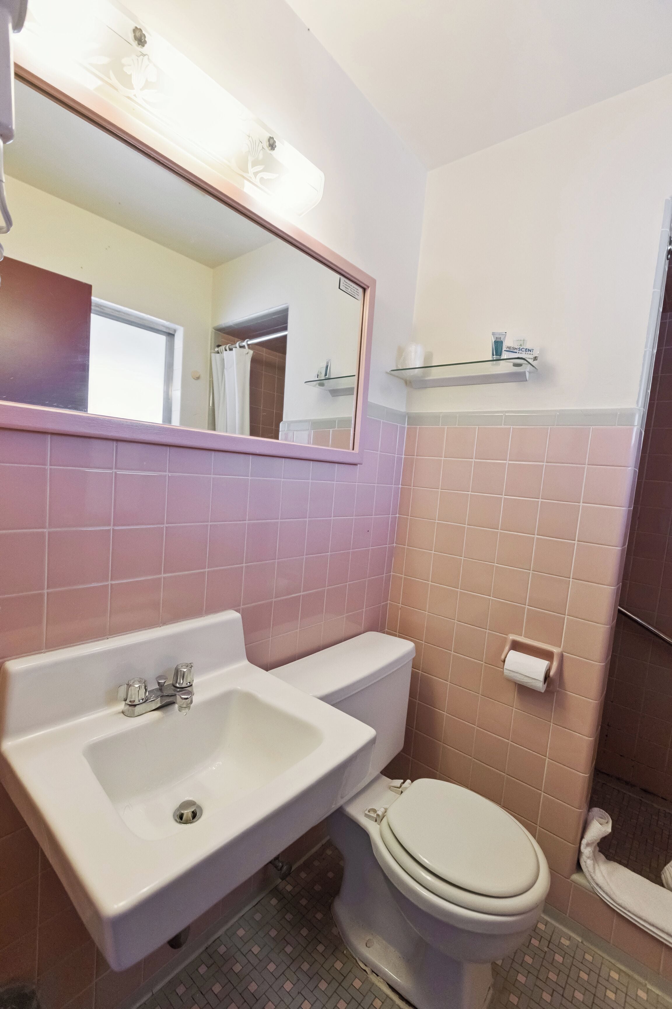 Ein Badezimmer mit Waschbecken, Toilette und Spiegel.