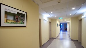Un largo pasillo de hotel, con paredes color crema y alfombra gris.
