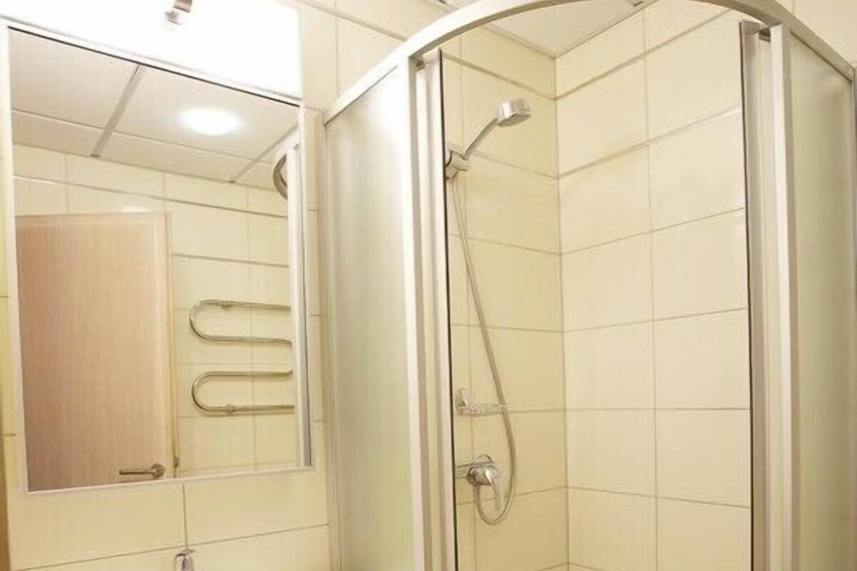 Une salle de bain avec une douche à parois de verre, un lavabo et un miroir.